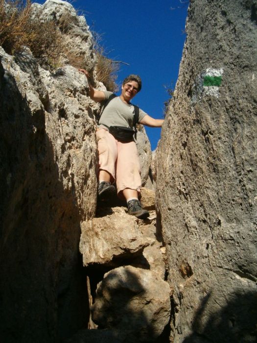 Diana climbing down cliff.
