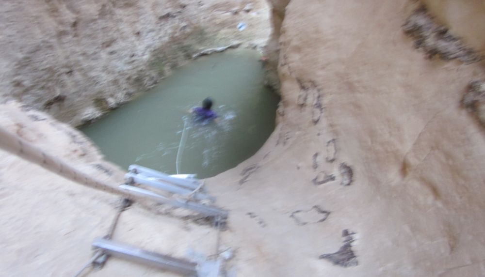 Diana swimming across the pool carrying the rope